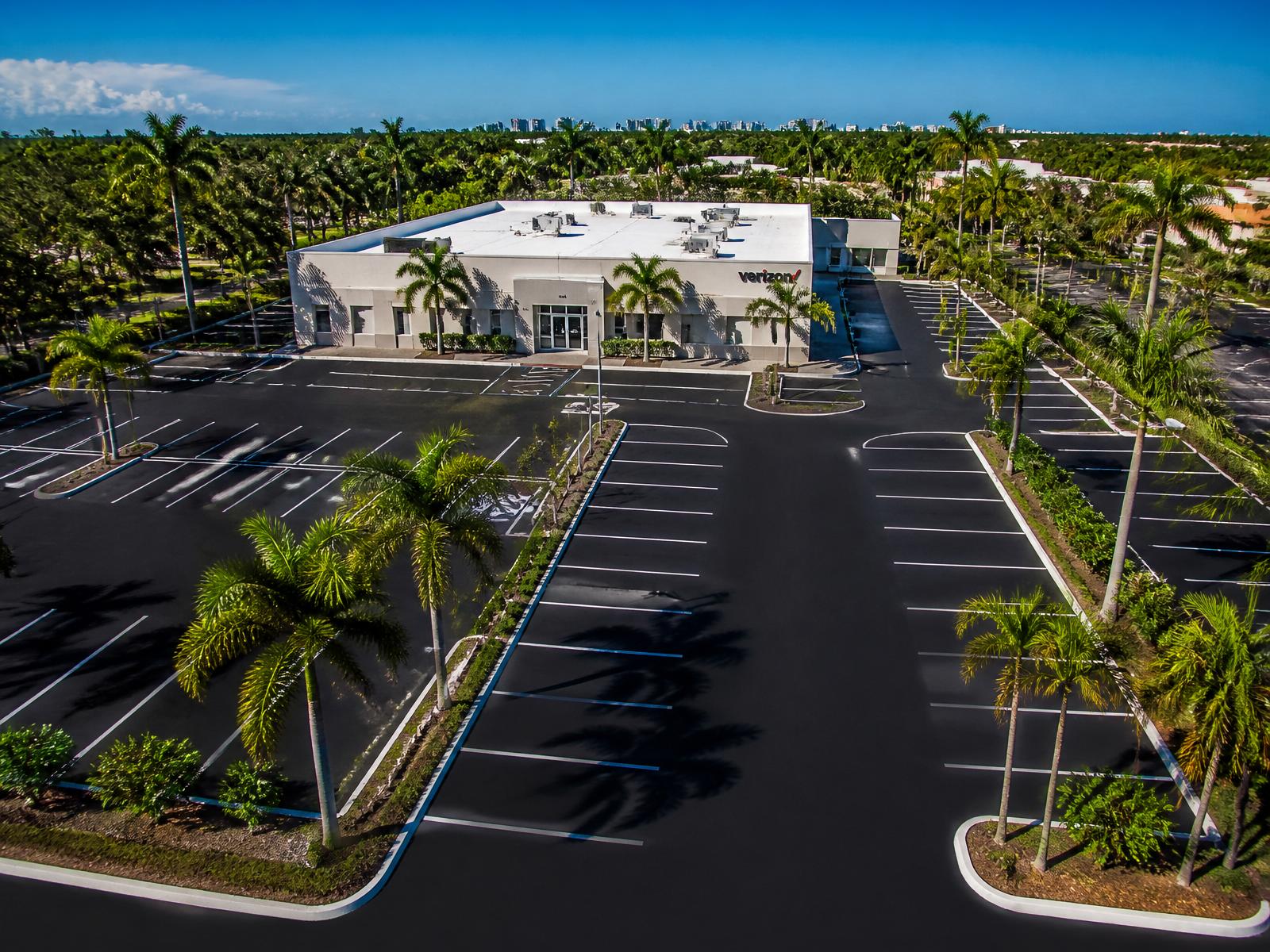 Freshly paved commercial parking lot in Florida framed by palm trees